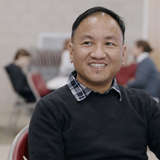 Refugee smiling and talking to ESL teacher.